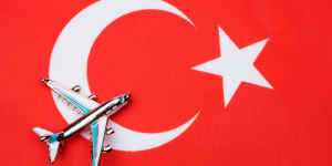 A miniature airplane placed on the Turkish flag, symbolizing travel to Turkey.