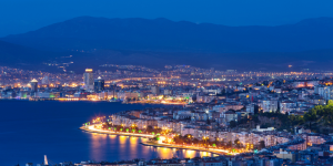 A stunning nighttime view of Izmir Bay with city lights reflecting on the water.