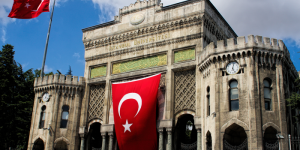 Historic main gate of Istanbul University with Turkish flag, a symbol of higher education in Turkey for international students.