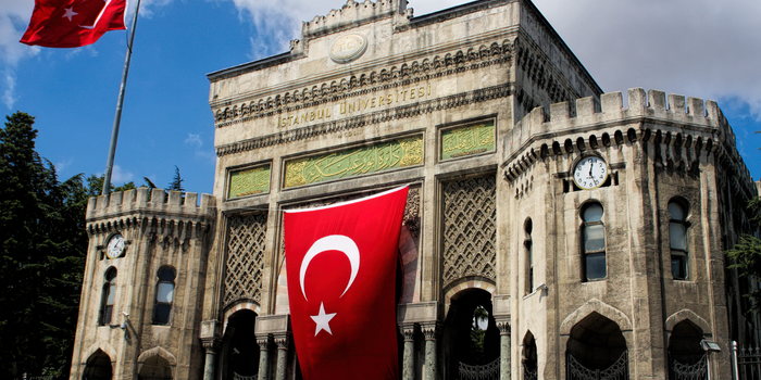 Historic main gate of Istanbul University with Turkish flag, a symbol of higher education in Turkey for international students.