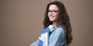 Smiling international student holding books, representing the academic opportunities available in Turkey.