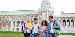 A group of international students walking and chatting outside a historical university building in Turkey.