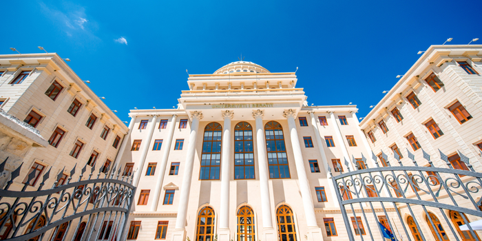 A modern university building with a blue sky background, representing Turkish higher education.